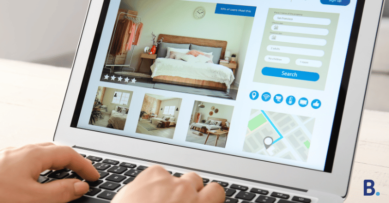 A person is using a laptop to browse a short-term rental booking website. The screen displays a room with a bed, various smaller room images, rating stars for optimal visibility, a search form, and a map.